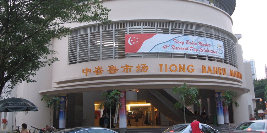 Two-level hawker centre with a red roof and signage, one the things to do in Tiong Bahru.