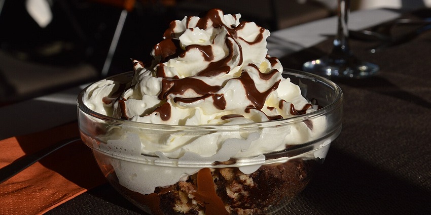 Somlói Galuska with sponge cake, chocolate sauce, and whipped cream, showcasing the best food in Hungary.