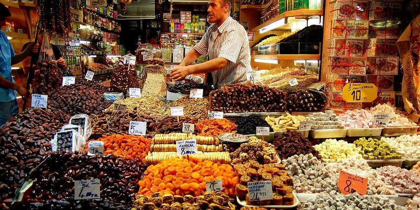 Heaps of colourful spices, from saffron to sumac, are displayed in an open-air spice market.