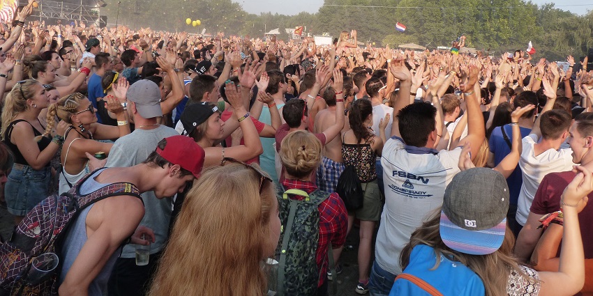 People dancing and cheering in front of the main stage during a live performance at the Sziget Festival.