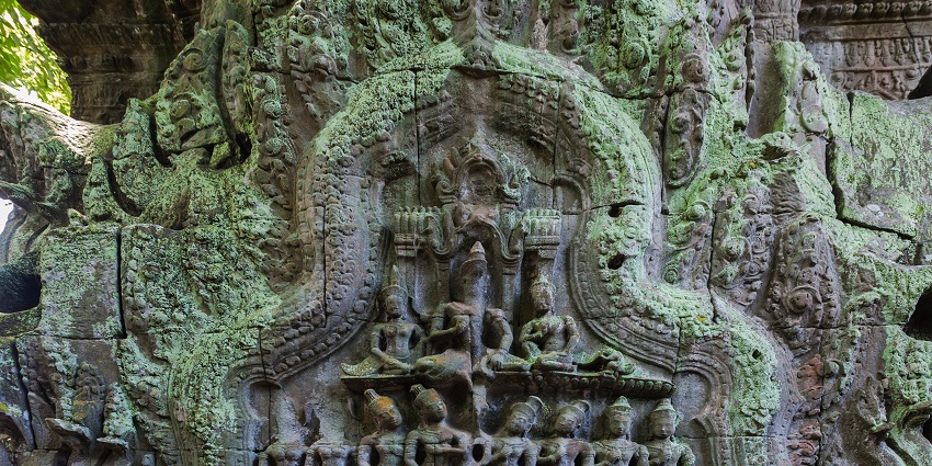 Large tree roots growing over Ta Prohm temple ruins near Banteay Kdei