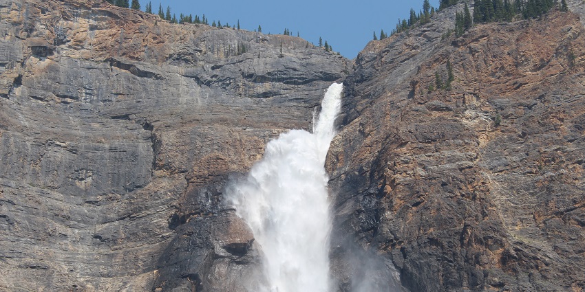 The awesome Takakkaw Falls viewed from its base, amidst gigantic mountains