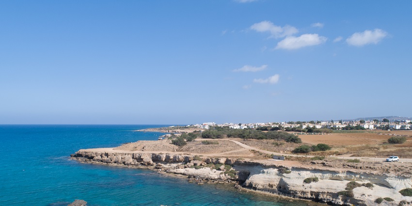 A beautiful view of a serene bay with crystal clear blue waters in Cyprus during the day