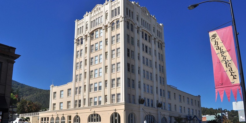Historic Ashland Springs Hotel with its tall structure and simple yellow façade.
