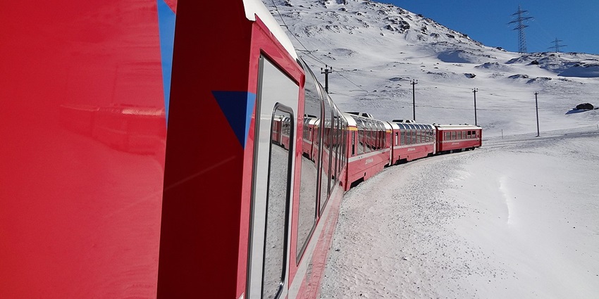 The Bernina Express train winding through snowy landscapes on a UNESCO rail journey.