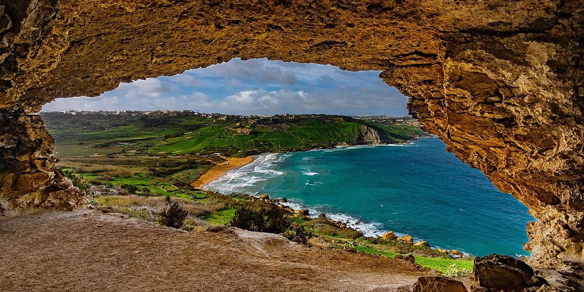 An image of panoramic view of Ramla Bay from inside Tal-Mixta Cave in Gozo, Malta.