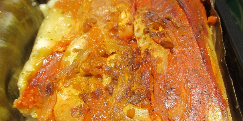 A serving of Tamal de Olla with chicken, olives, and vegetables in corn dough.
