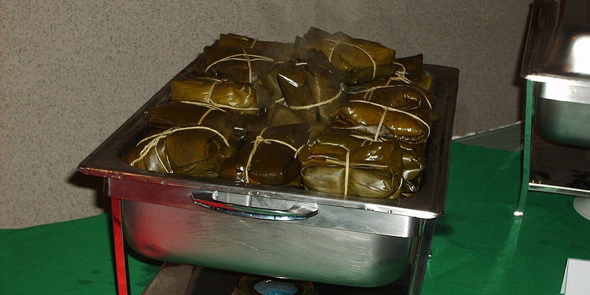 An image showing traditional tamales wrapped in leaves, a common food in Costa Rica.