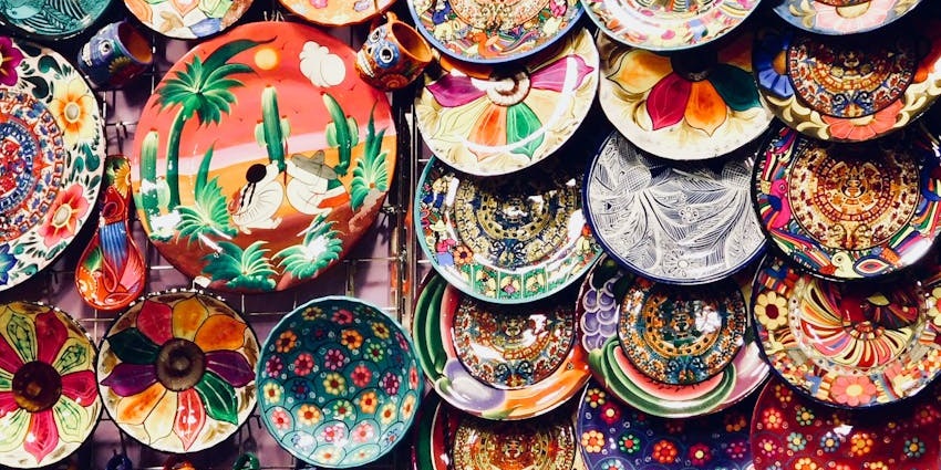 Hand-painted commemorative plates in vibrant colors displayed at a market stall
