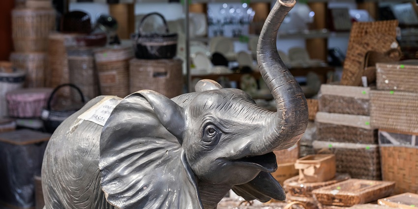 Hand-carved wooden elephants in a market stall in Phuket are one of the nice things to buy in Phuket.
