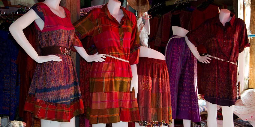 Image of Thai silk dresses displayed in a Phuket market, one of the best things to buy in Phuket.