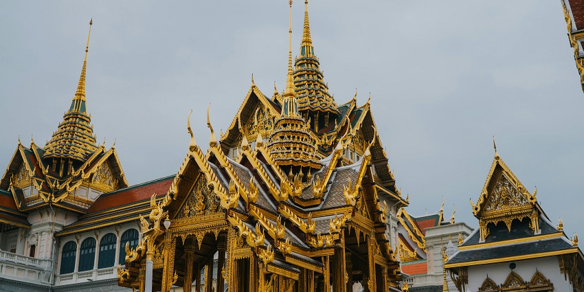 A glimpse of the Grand Palace featuring intricate designs and golden artwork in Thailand.