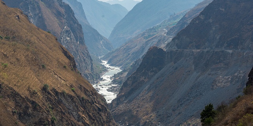 The Tiger Leaping Gorge shows a narrow river running through a gorge in steep mountains