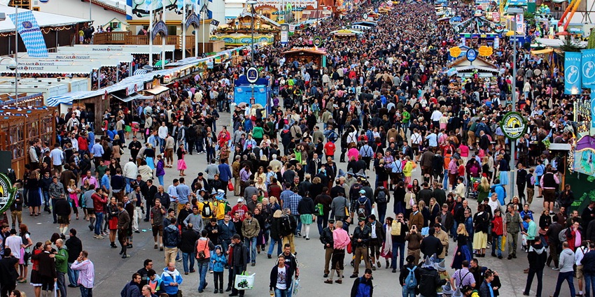 Oktoberfest in Munich with a huge crowd of people and different tents and rides