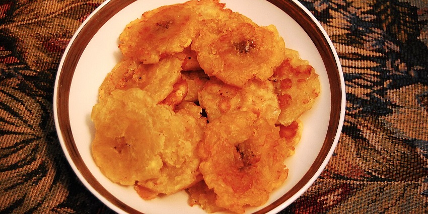 An image showing a plate of tostones prepared from sliced and fried green plantains.