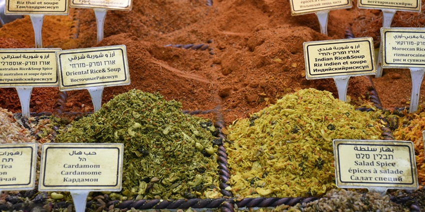 Various fresh Thai spices such as chilli, galangal, and herbs laid out at a local market stall.
