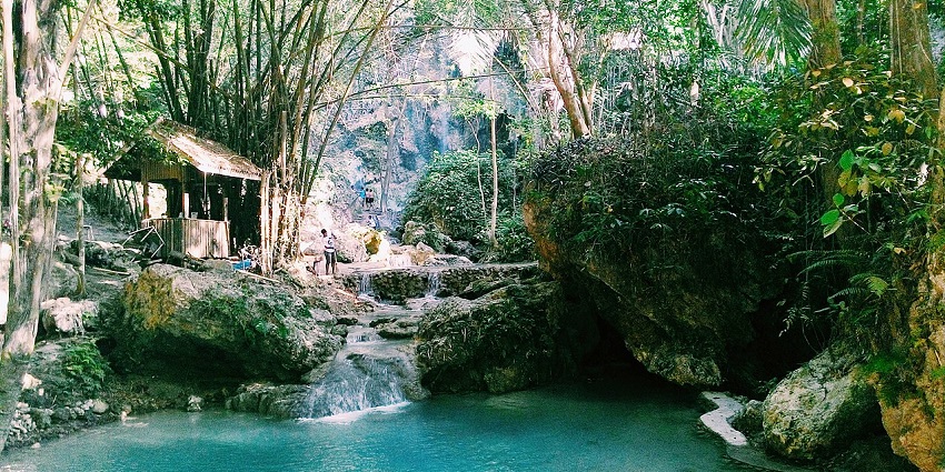 Tumalog Falls in Cebu, a beautiful waterfall surrounded by lush greenery and calm waters