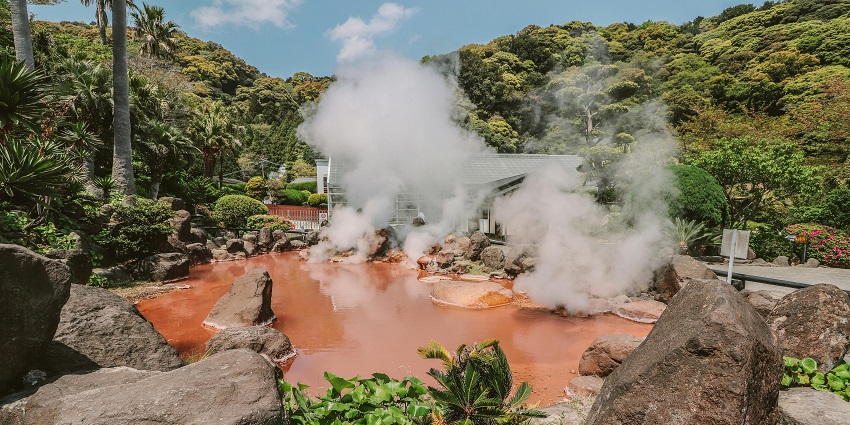 Natural hot springs with steam rising, surrounded by greenery and rocks—relaxing things to do in Chiang Rai.