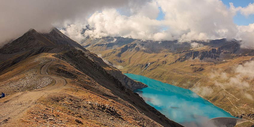 Val d’Anniviers Valley with a lake and cloud-covered hills in valleys in Switzerland.