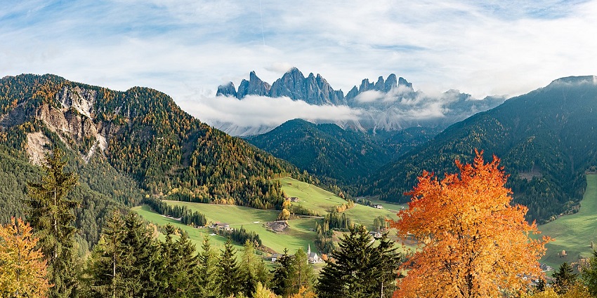 A serene image of Val di Funes covered in dense greenery, one of the best valleys in Italy.
