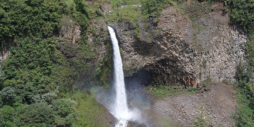 Velo de novia waterfalls with water falling, forming a river-like water body and greenery