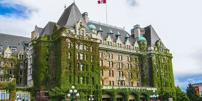 Scenic view of Victoria's Inner Harbour with historic buildings and docked boats, an elegant place to visit near Vancouver.