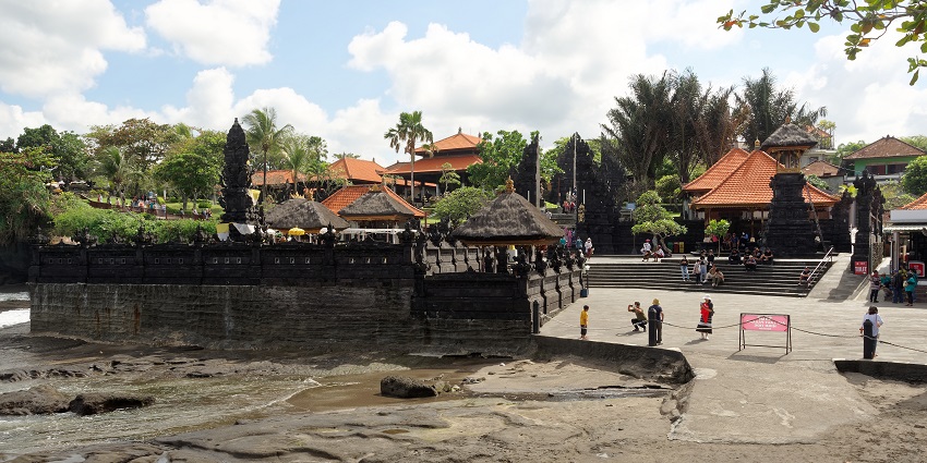 Tourists capturing fun moments at Tanah Lot Temple, one of the things to do in Tabanan.