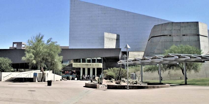 Children interacting with science displays, surrounded by lights and educational exhibits.