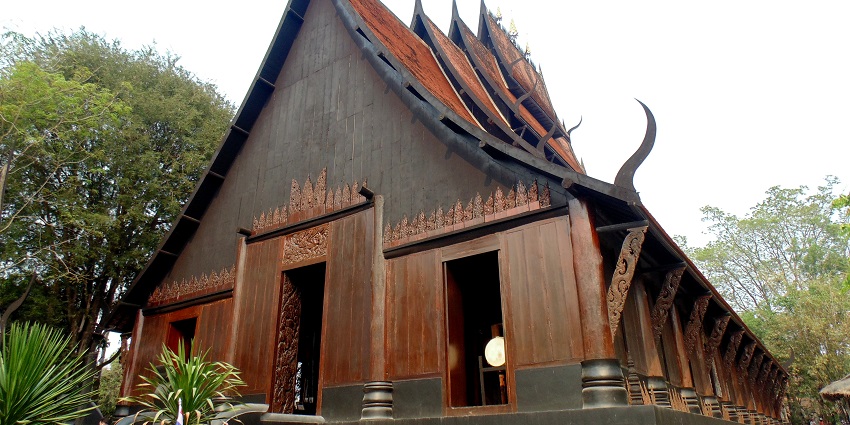 Baan Dam Museum features black wooden buildings, tribal instruments, animal bones, and unconventional Thai artistic themes.