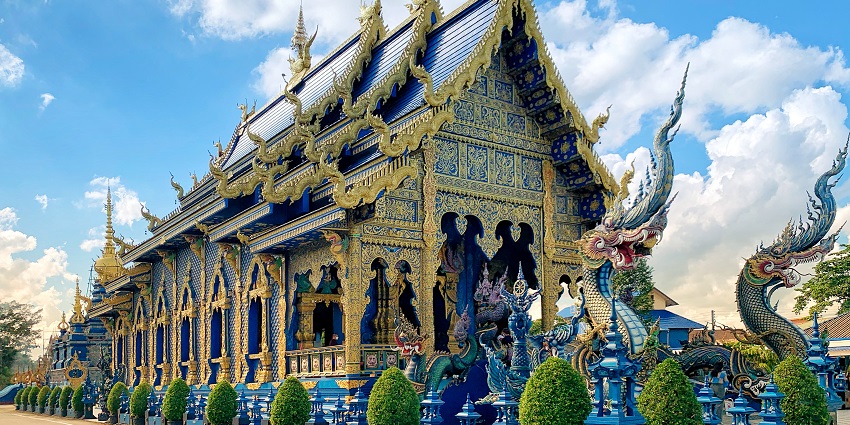 Wat Rong Suea Ten, known as the Blue Temple, features vivid sapphire hues, intricate carvings, and a glowing white Buddha in serene brilliance.