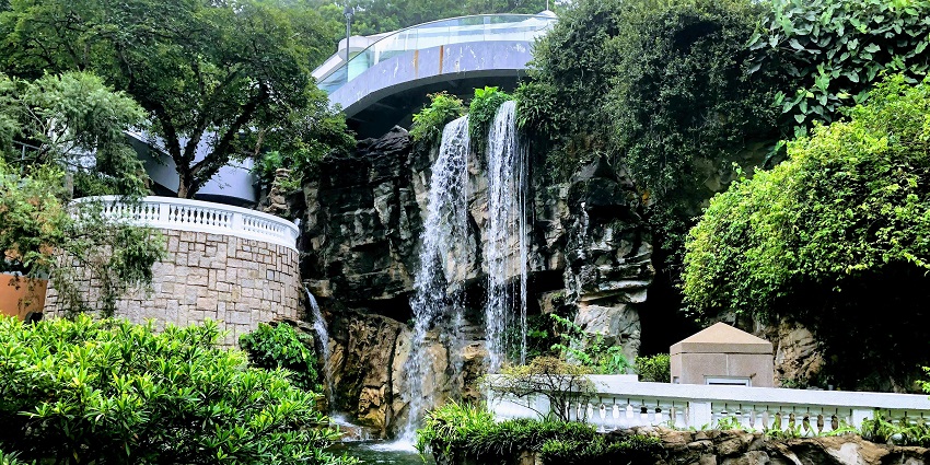 Waterfall at Singapore Botanic Gardens with visitors admiring the lush greenery.
