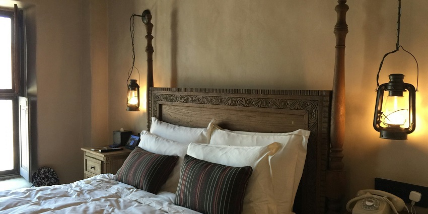 An image of a hotel room featuring a comfortable bed, modern furnishings, and soft lighting.