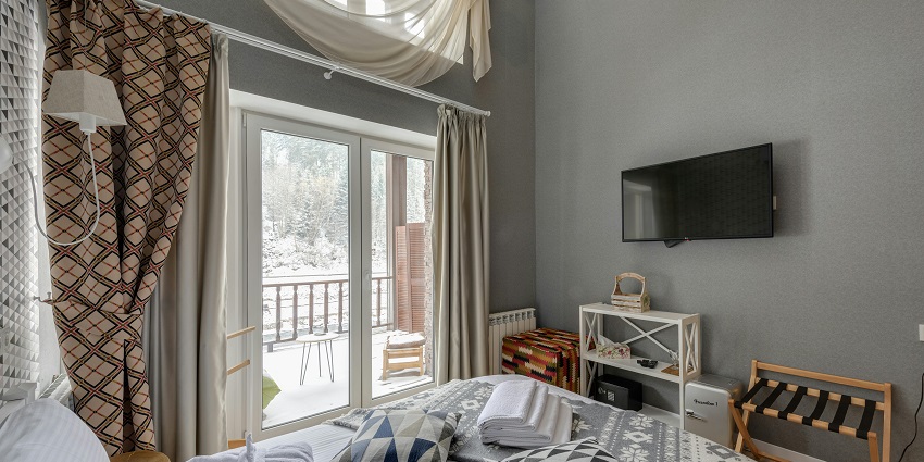 A cozy bedroom with soft lighting and a snowy outdoor view, offering a serene retreat.