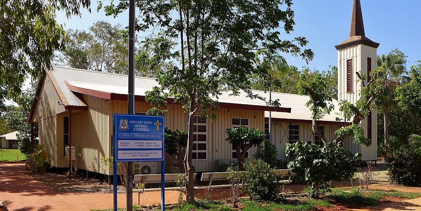 A blue signboard with a description of the premises of Our Lady Queen of Peace Cathedral.