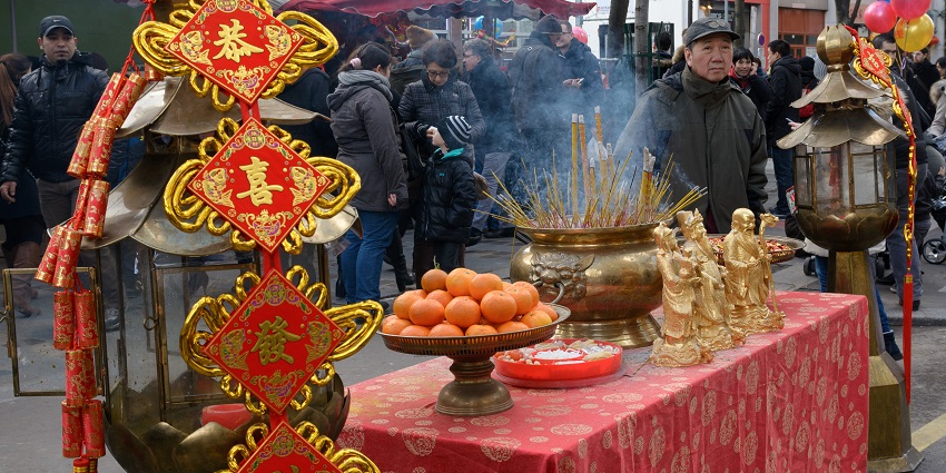 Table with incense sticks and Buddha statues during Chinese New Year celebrations