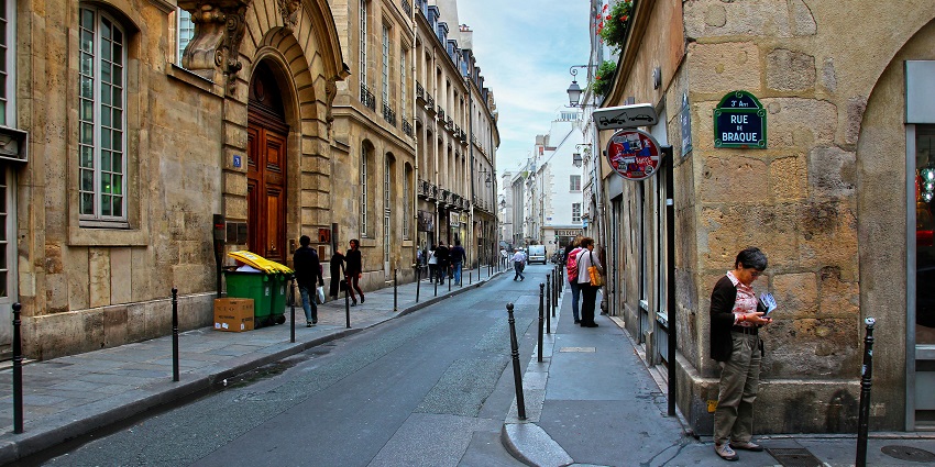 Shoppers strolling through the stylish streets of Le Marais – where to shop in Paris.