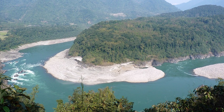 Clear water body of the river Siyom in Aalo with sandy shores, green trees and mountains
