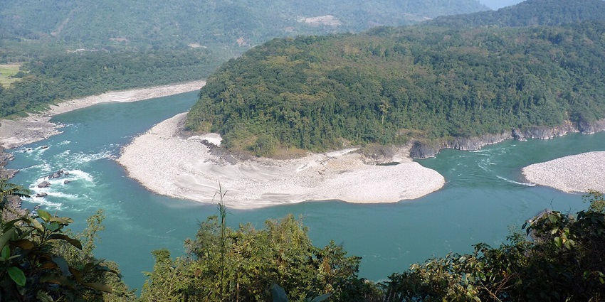 Clear water body of the river Siyom in Aalo with sandy shores, green trees and mountains