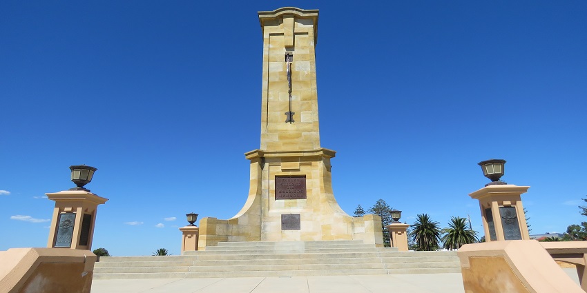 A tall white obelisk under the clear sky, representing one of the historical monuments in New Zealand.