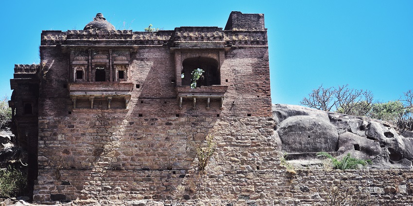 Front facade of a Jain temple in Rajasthan with architecture and multiple white statues.