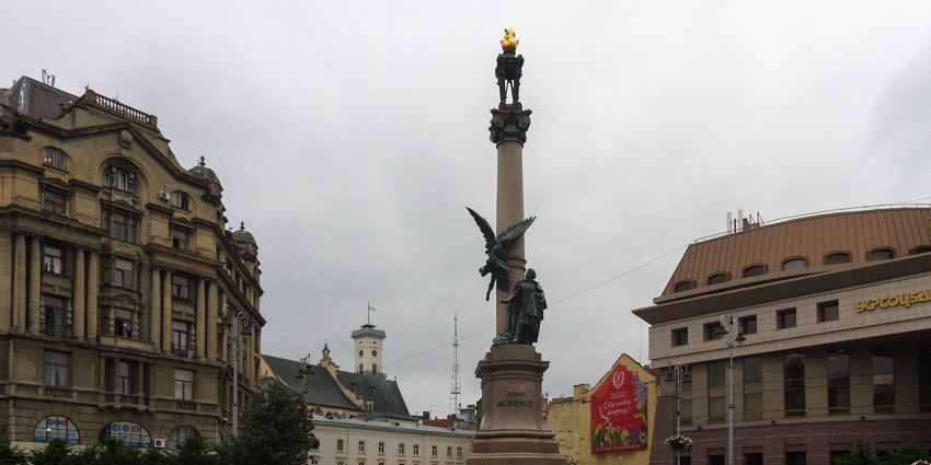 View of the statue of Adam Mickiewicz standing on a pedestal in Lviv’s city centre square.
