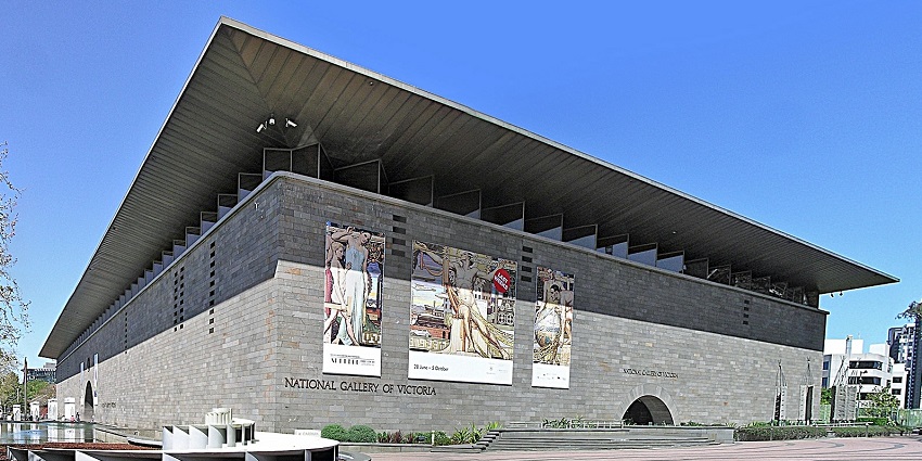 Facade of the National Gallery entrance with people walking by and a water wall feature.