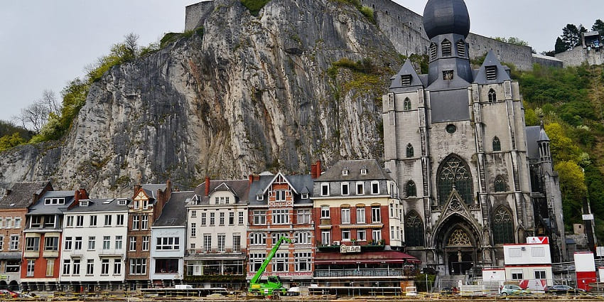 Things to do in Dinant, Belgium, include exploring the Gothic church with a tall spire beside the Meuse River.