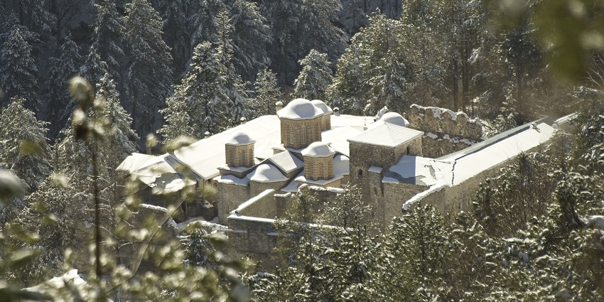 Agios Dionysios Monastery in winter with the roof of the building fully covered in snow.