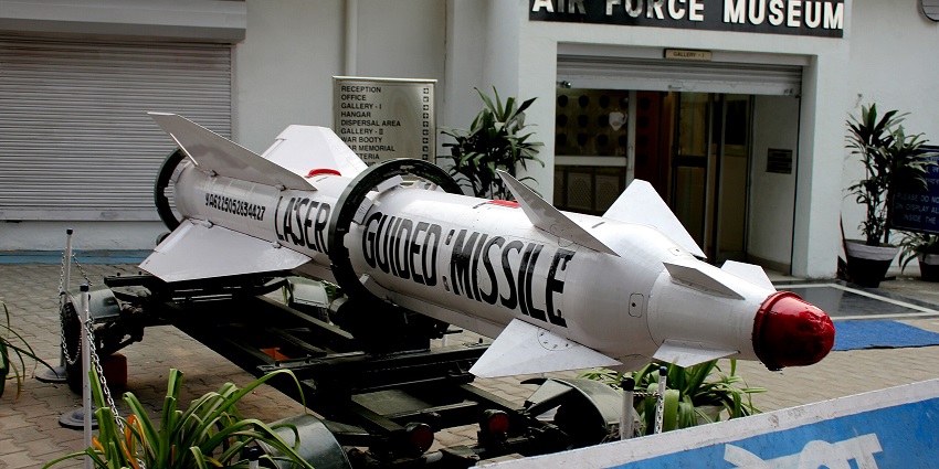 Entrance to the Indian Air Force Museum with multiple sign boards and a missile model.