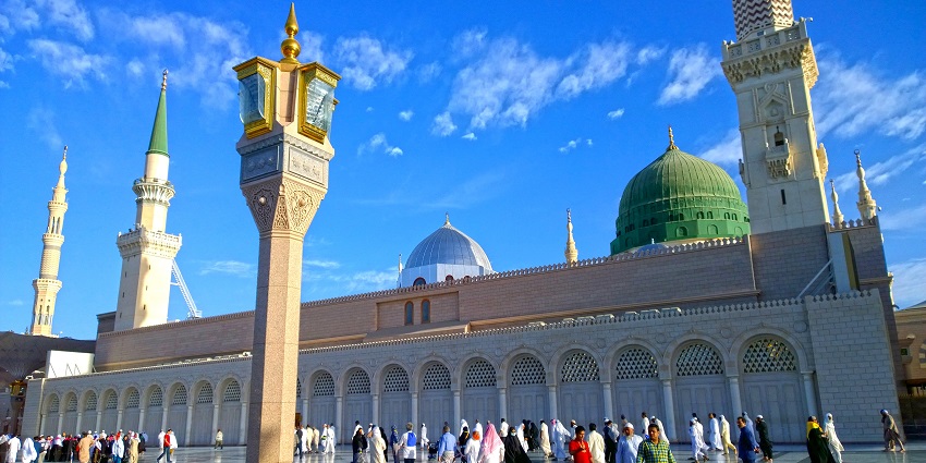 Al-masjid an-Nabawi with traditional Islamic architecture, green domes, one of the historical places in Saudi Arabia.
