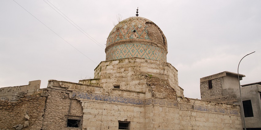 Great Mosque of al Nuri with Islamic architecture, a tall minaret and people sitting on the stairs