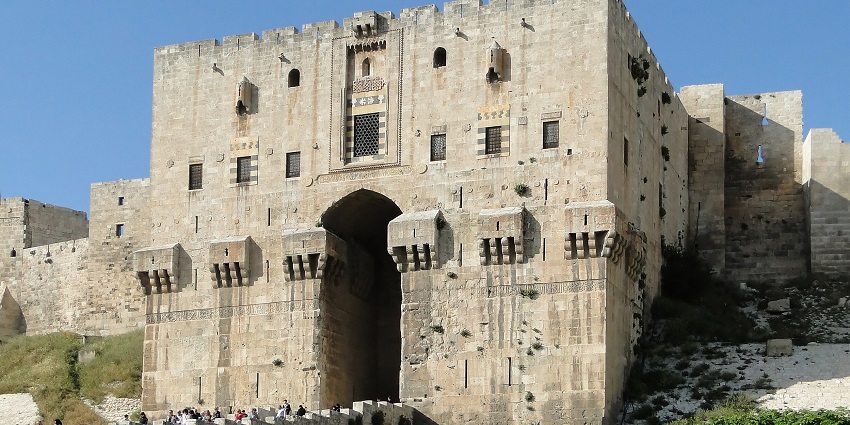 Aleppo citadel with people walking on the bridge and the traditional architecture, one of the historical places in Syria.