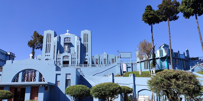 Church in Shillong with black & white architecture, multiple windows and electricity wire poles