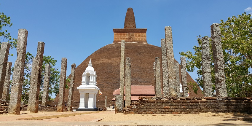 The ancient Abhayagiri Dagoba, a large white stupa surrounded by trees, located in Anuradhapura, is one of the iconic monuments in Sri Lanka.